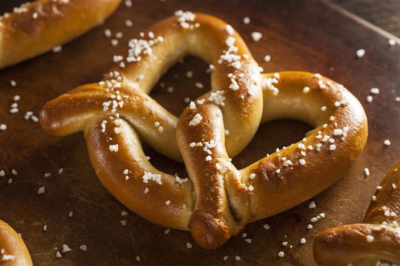 A giant pretzel on a wood board 