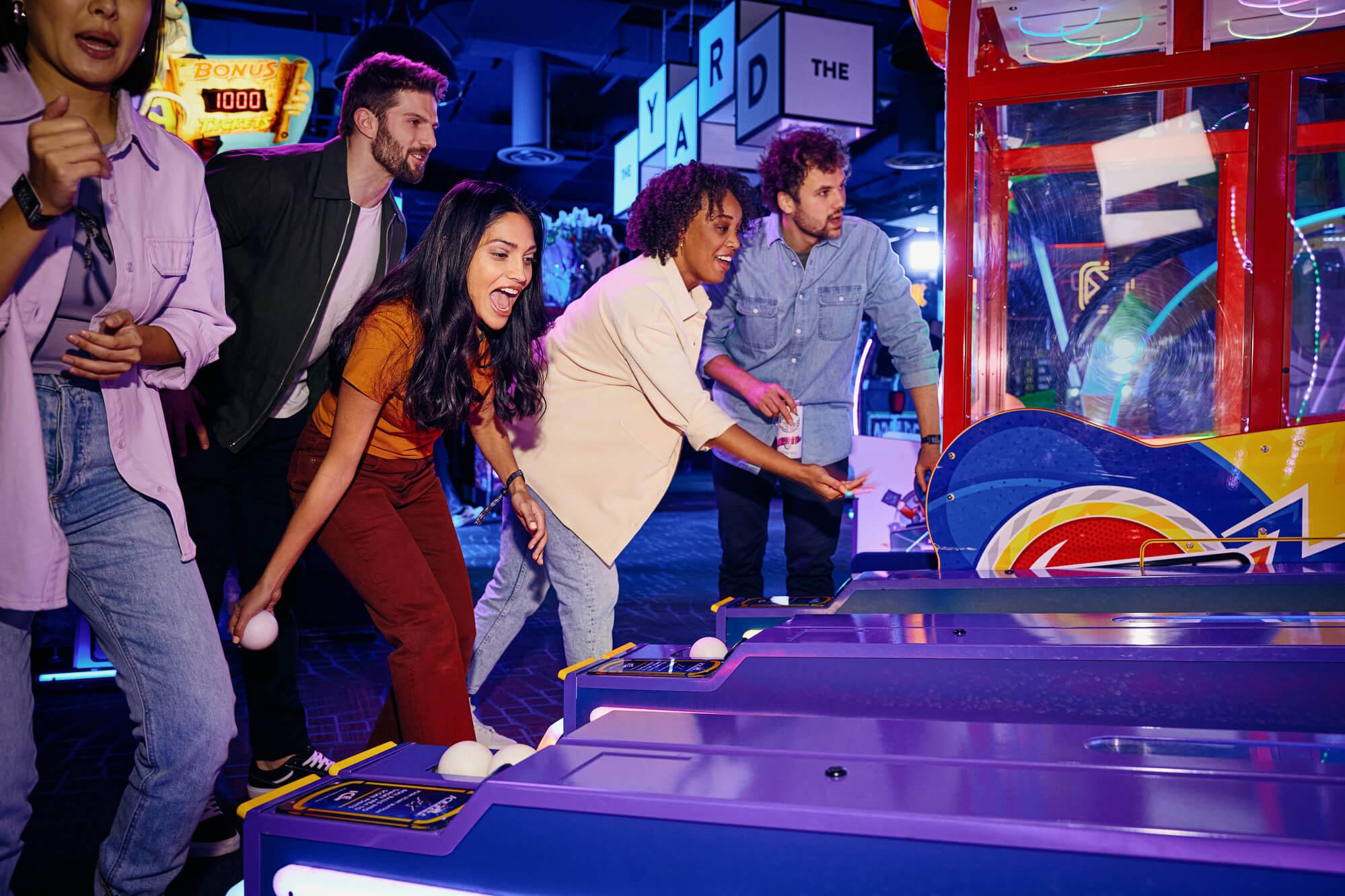 Friends excitedly playing skeeball.