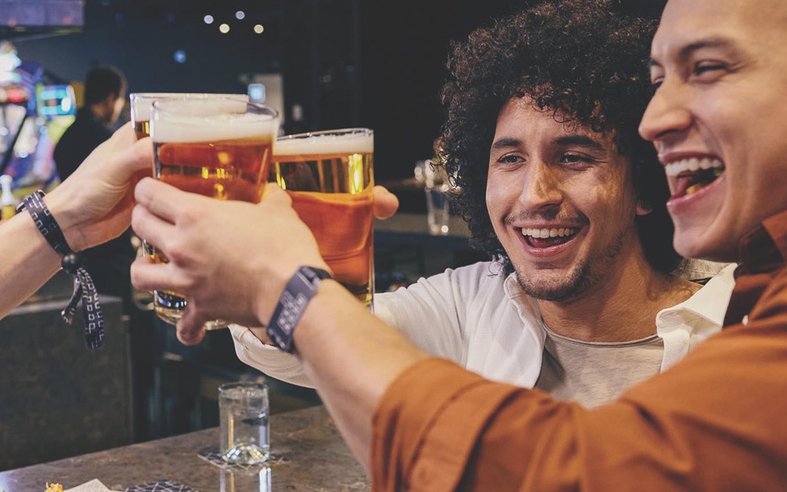 Friends cheering with drinks at the bar  